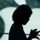 A customer uses her new smartphone during the release of the iPhone 6s at an Apple store in Shanghai on September 25, 2015.